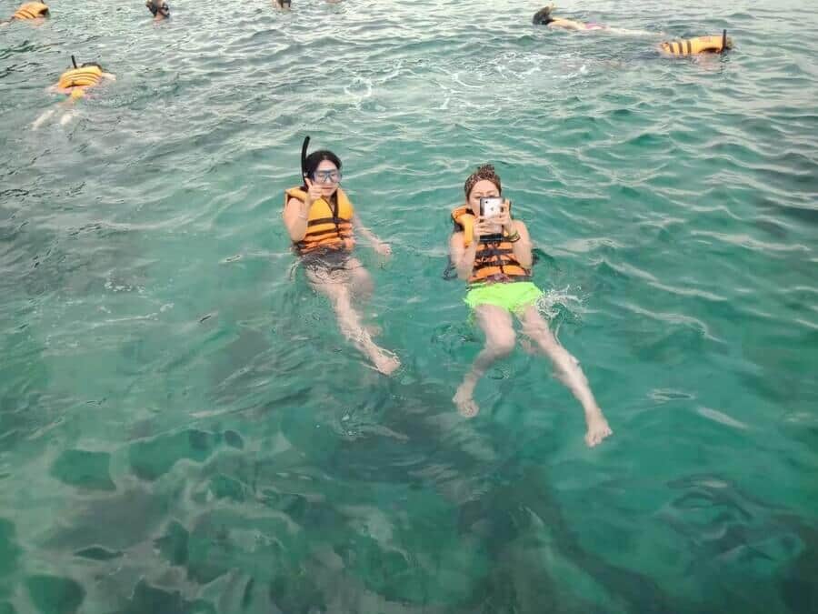 Snorkelers in life jackets in the clear water off Phi Phi Island